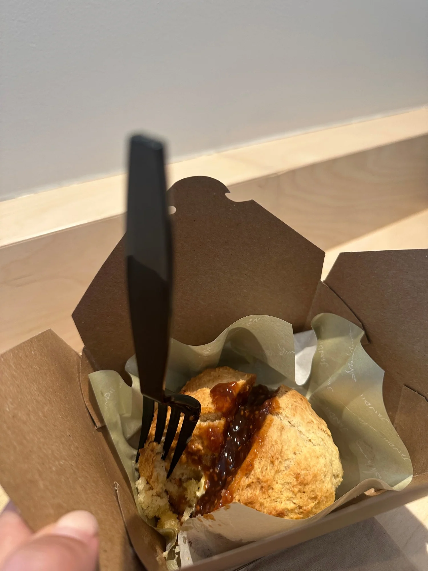 A raspberry scone with jam in a takeout box at Jandii Cafe San Francisco