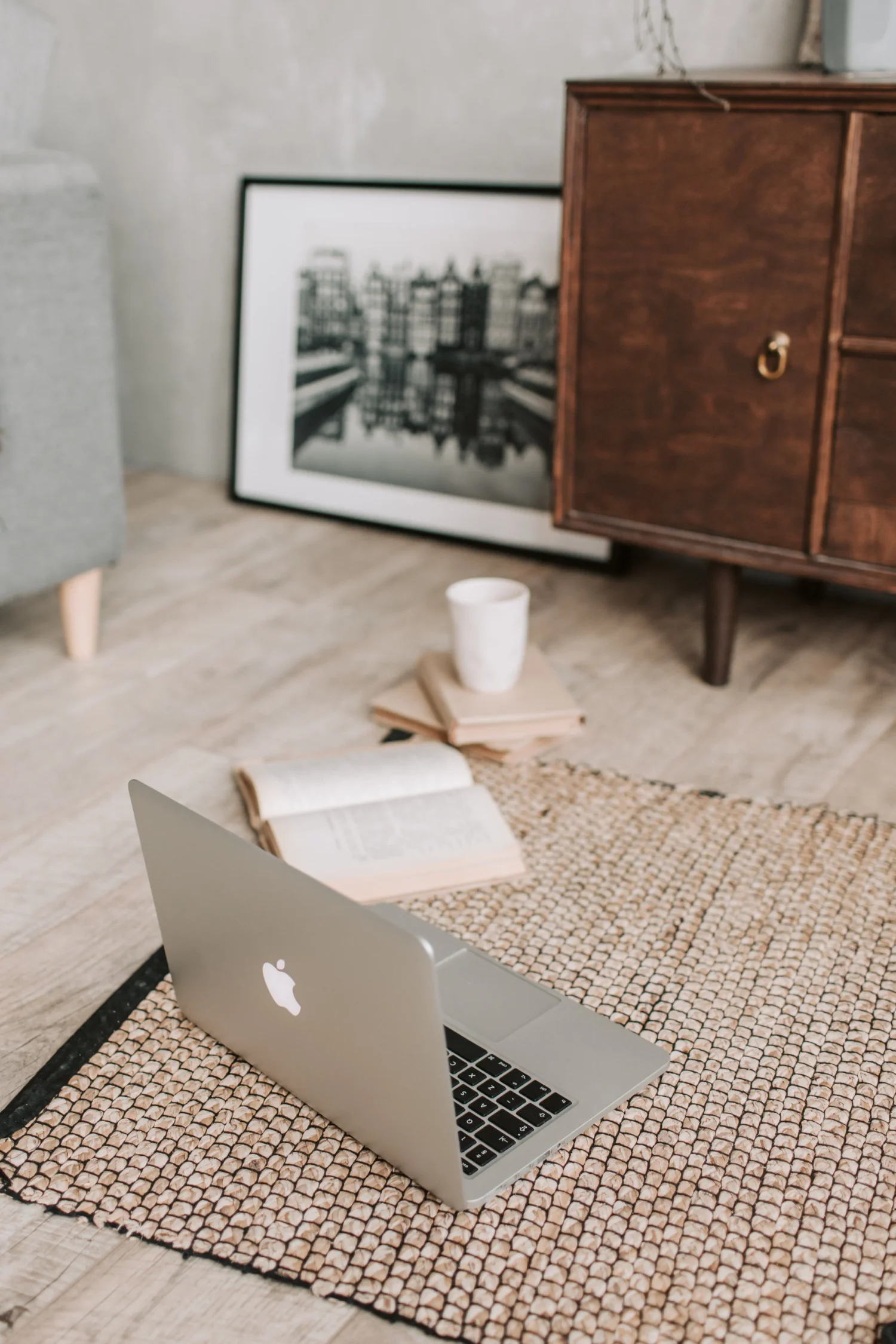 Laptop, open book, and coffee in a cozy workspace, representing the focused, in-depth manuscript refinement process offered by Amy Suto as a developmental editor.