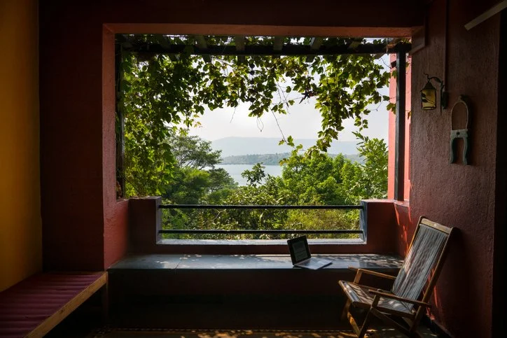 Scenic outdoor workspace with a laptop overlooking lush greenery, representing the freedom and versatility of creating and selling writing packages as a freelancer through Amy Suto’s guidance.