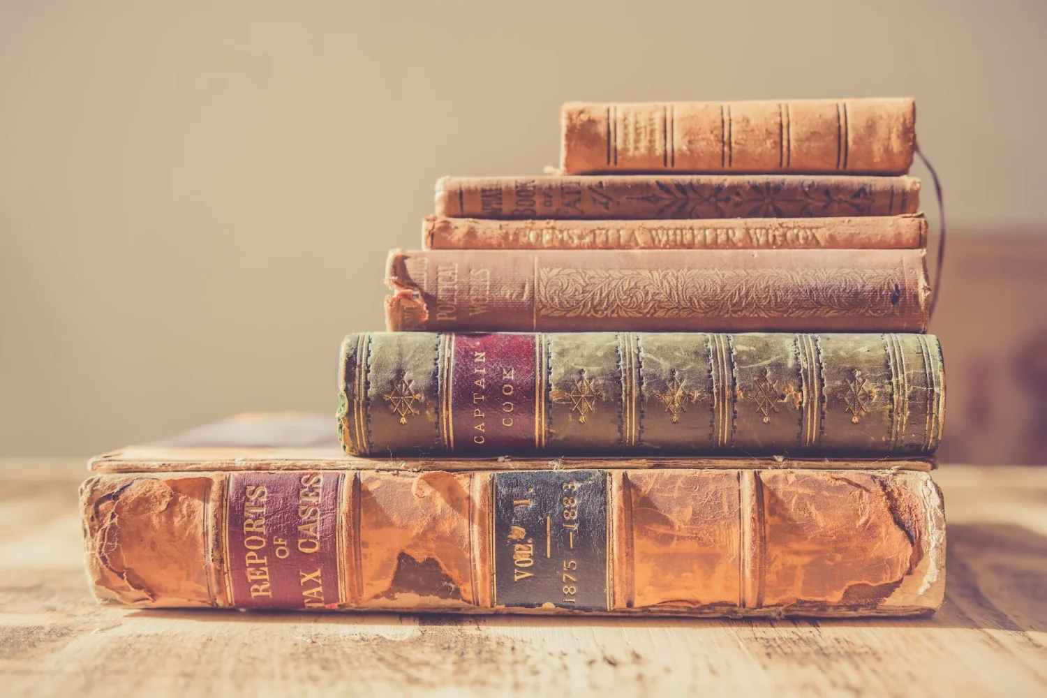 A stack of weathered, antique books, symbolizing the art of memoir writing and the timeless stories Amy Suto helps bring to life through her ghostwriting services.