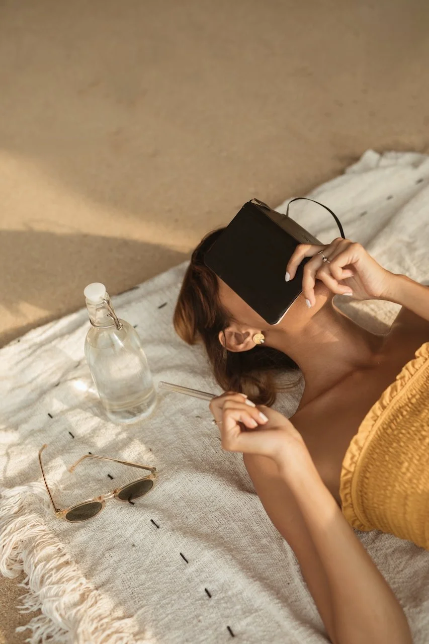 Person lying on a blanket with a notebook, capturing reflective moments that can inspire memoir writing, aligning with the theme of what a memoir ghostwriter does.