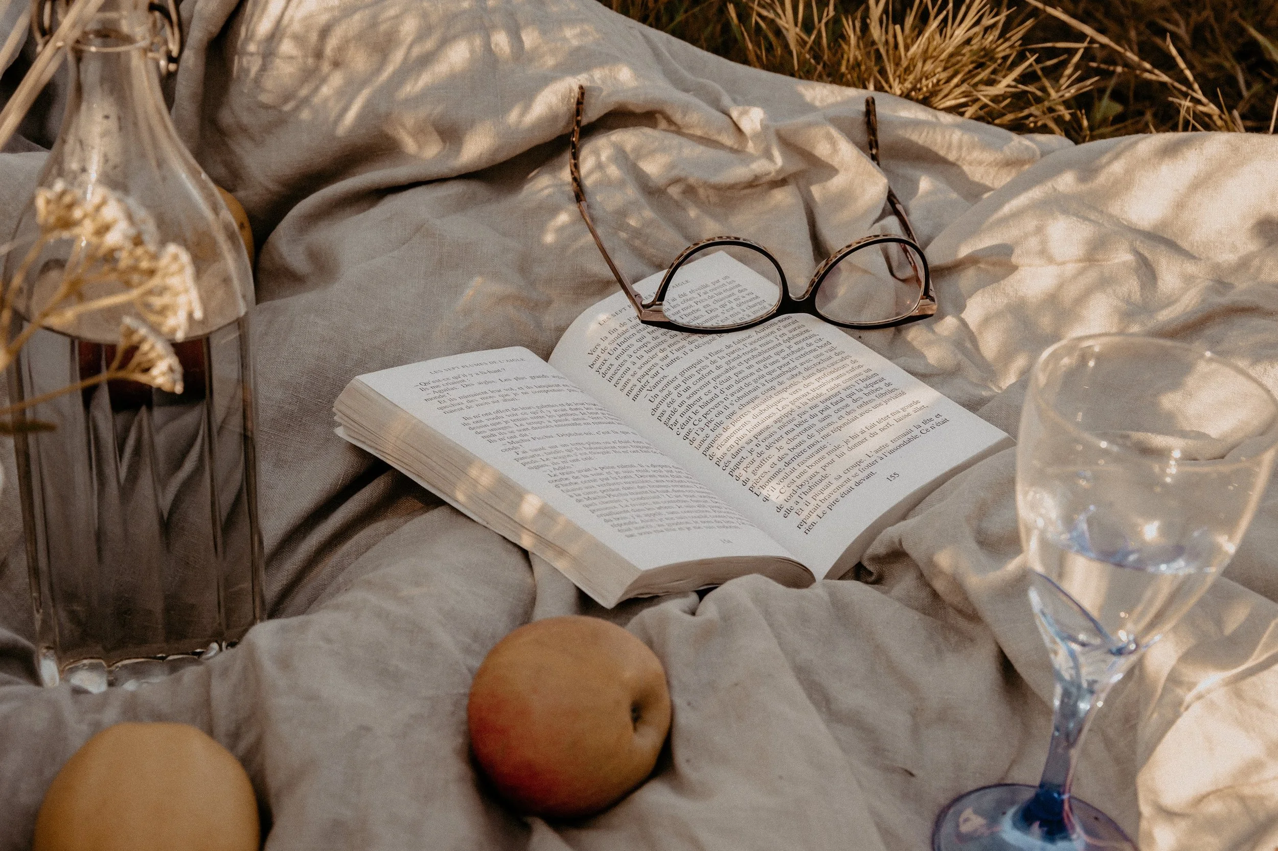 Memoir-in-progress on linen with reading glasses in natural light — a reminder that every founder, entrepreneur, or coach can hire a ghostwriter to tell their story