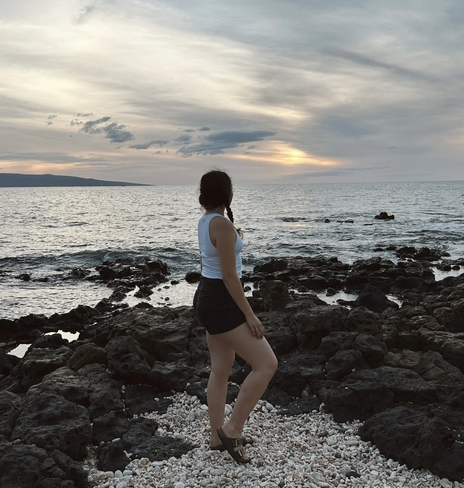 Amy Suto standing on the lava-rock shoreline at Wailea Beach in Maui, Hawaii, watching the Pacific Ocean sunset. Captured for AmySuto.com’s Maui travel guide, showcasing the island’s tranquil beaches and golden evening light.